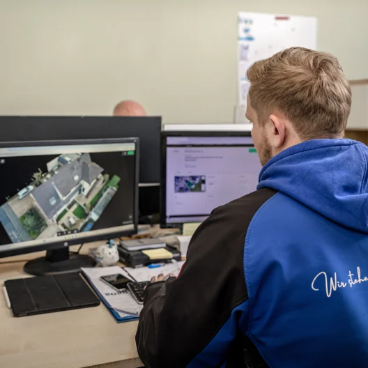 Mitarbeiter des Teams van Waasen analysiert Drohnenaufnahmen eines Gebäudes am Computer