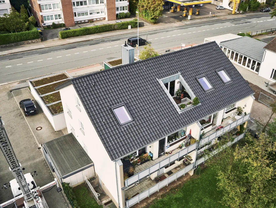 Fertiggestelltes Mehrfamilienhaus mit neuem Ziegeldach und Dachflächenfenstern, Drohnenaufnahme