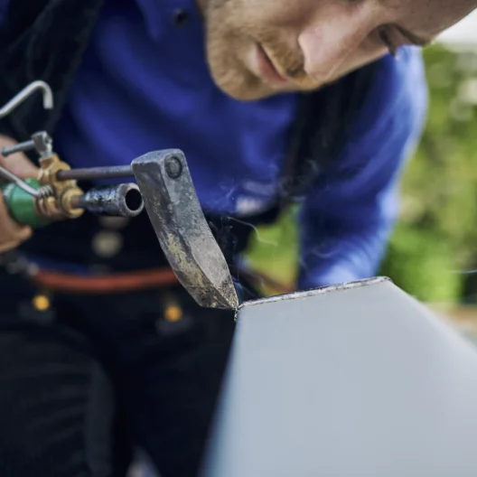 Mitarbeiter des Teams van Waasen bei Spengler-Arbeiten an einem Metallblech